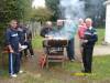 Members cooking around the oil drum barbecue